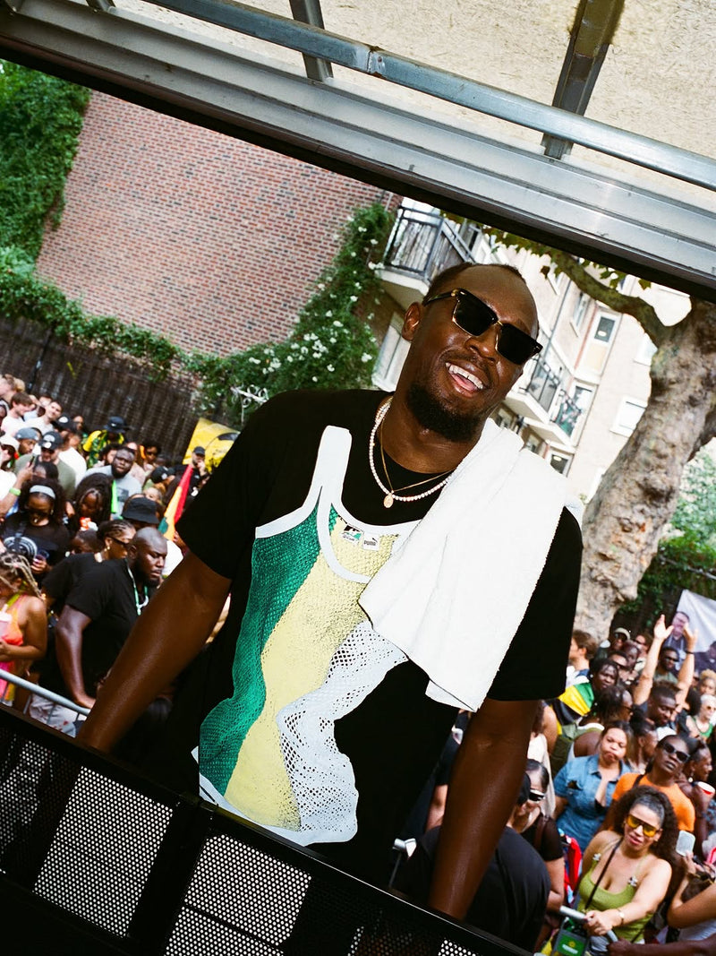 Usain Bolt wearing Sharkinni Carnival tee in front of Notting Hill Carnival crowd